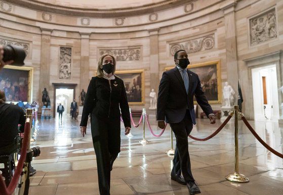 미 하원 탄핵소추위원들이 25일 도널드 트럼프 전 대통령의 내란 선동 혐의를 기재한 탄핵 소추안을 전달하기 위해 상원으로 향하고 있다. 트럼프 지지자들이 난입한 국회의사당 원형 돔 아래를 지나고 있다. [AFP=연합뉴스]