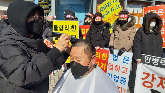 한국유흥업협회 충남 서산지부 주최로 지난 8일 서산시청 앞에서 열린 유흥업소 집합금지 명령 철회 촉구 집회에서 한 회원이 항의 표시로 삭발을 하고 있다. 연합뉴스