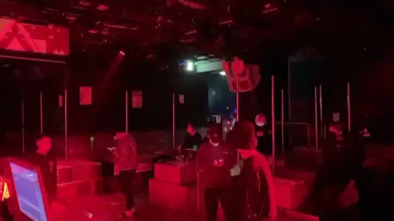 16일 오전 서울 강남의 한 클럽 내부. 붉은 조명 아래서 'X' 표시 위에 선 사람들이 휴대전화를 보거나 몸을 움직이고 있다. 정진호 기자