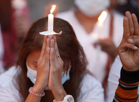 미얀마 양곤에 있는 미 대사관 앞에서 20일 한 시위자가 촛불을 켜고 기도를 드리고 있다. [EPA=연합뉴스]