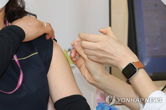 27일 오전 서울시 중구 을지로 국립중앙의료원 중앙예방접종센터에서 화이자 백신 1호 접종자인 환경미화원 정미경씨가 주사를 맞고 있다. 연합뉴스