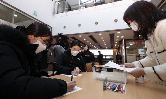 세종시 첫 코로나19 백신 접종자인 요양병원 간호사 이하현(24)씨와 고은주씨(28)씨가 지난달 26일 오전 세종시보건소에서 코로나19 아스트라제네카(AZ) 백신 접종에 앞서 예진표를 작성하고 있다. 연합뉴스