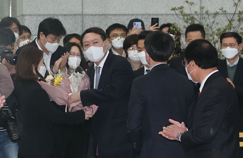 전격적으로 사의를 표명한 윤석열 검찰총장이 4일 오후 서울 서초구 대검찰청 청사를 나서던 중 직원에게 꽃다발을 받고 있다. 문재인 대통령은 윤 총장의 사의를 한 시간여 만에 수용했다. 연합뉴스