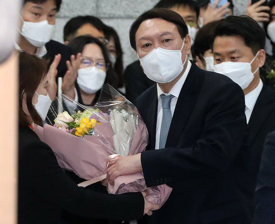 지난 4일 사의를 표명한 윤석열 검찰총장이 직원들과 인사를 나눈 뒤 꽃다발을 들고 대검찰청 청사를 나서고 있다. 김경록 기자