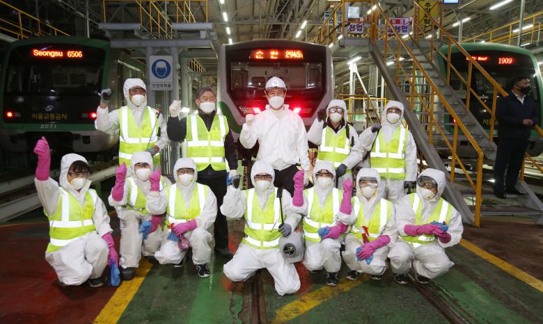 오세훈 국민의힘 서울시장 후보가 25일 새벽 군자차량사업소에서 전동차 방역을 마친 뒤 관계자들과 기념촬영을 하고 있다. 국회사진기자단