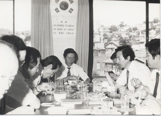 농심 임직원들과 당시 신제품이던 컵라면을 맛보고 있는 故 신춘호 회장(가운데). '나는 삶의 철학을 가진 인간이다', '나는 경제를 아는 인간이다', '나는 행복한 인간이다'라는 농심의 사훈이 벽에 걸려있다. 사진 농심