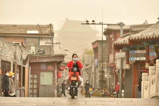 28일 중국 베이징시에서 한 여성이 마스크를 쓰고 오토바이를 타고 있다. 신화통신=연합뉴스