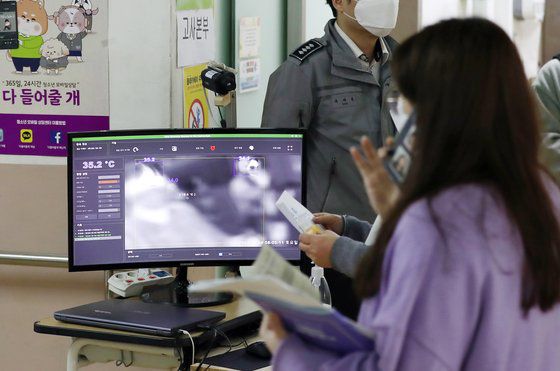10일 오전 서울 성북구 한 중학교에서 열린 고졸 학력인정 검정고시에 응시한 수험생들이 고사장에 입실하며 방역 지침에 따라 체온을 확인하고 있다.   연합뉴스