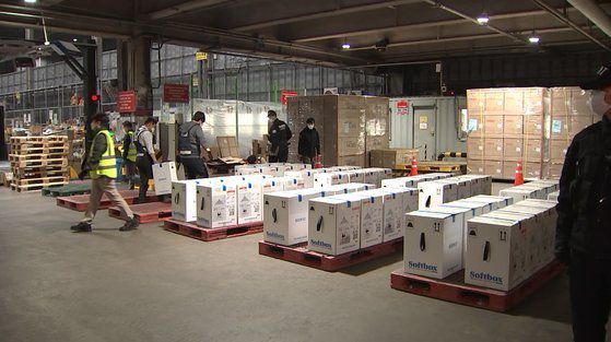 지난 12일 새벽 인천국제공항에서 공항직원들과 방역 당국 관계자들이 UPS 화물항공편으로 도착한 화이자 신종 코로나바이러스 감염증(코로나19) 백신 43만8000회분을 옮기고 있다. 국방TV 캡처=뉴스1