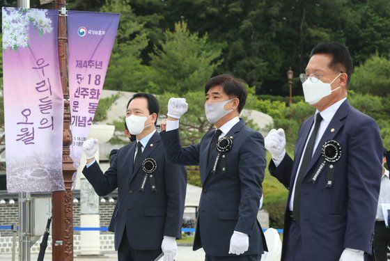 5·18 민주화운동 기념일을 하루 앞둔 17일 오전 광주 북구 국립 5·18 민주묘지에서 열린 추모제에 유족의 초청으로 참석한 국민의힘 성일종(왼쪽), 정운천(오른쪽) 의원이 김병욱 민주당 의원(가운데)와 함께 '임을 위한 행진곡'을 부르고 있다. 연합뉴스