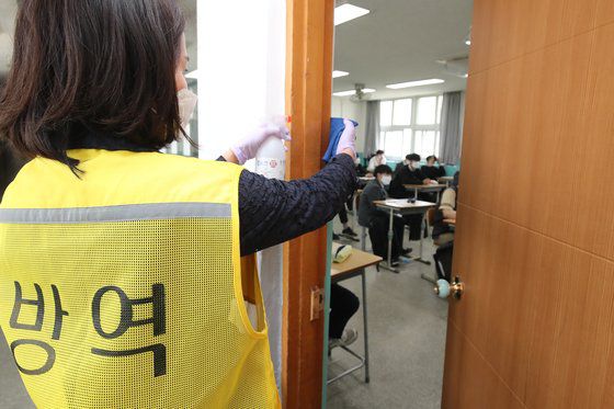 29일 대구 남구의 한 고등학교에서 학교전담 방역요원이 교실 출입문 등 학생 출입이 잦은 공간을 소독하고 있다. 뉴스1