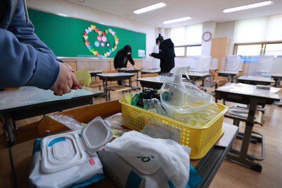 지난 2월 25일 오후 서울 서초구의 한 초등학교에서 교실 책상 가림막을 설치하고 책상과 가림막을 소독액으로 닦는 방역 작업이 실시되고 있다. 연합뉴스