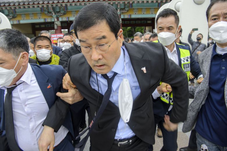 문흥식 5·18구속부상자회 회장이 지난 5월 18일 오전 광주 북구 운정동 국립5·18민주묘지에서 열린 제41주년 5·18민주화운동 기념식에 참석하던 중 5·18민주화운동 부상자회 공법단체 설립준비위원회 회원들의 항의를 받으며 묘지에 들어서고 있다. 뉴스1