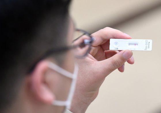 지난달 3일 오후 서울 강남구 로봇고등학교에서 자가검사를 마친 한 학생이 테스트기 결과를 확인하고 있다. 사진공동취재단.