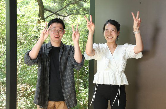 중앙일보 사옥에서 BTS 퍼미션 댄스 뮤직비디오에서 나온 국제 수화 중 '평화'를 뜻하는 포즈를 취하는 이준만씨와 박남희 한국농아인협회 대리. 우상조 기자