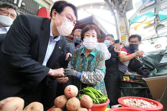 윤석열 전 검찰총장(왼쪽)이 20일 대구시 중구 서문시장을 찾아 상인과 대화하고 있다. [뉴스1]