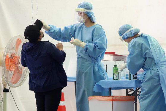 23일 오후 대구 달서구 두류야구장 임시선별검사소에서 의료진이 코로나19 진단검사를 이어가고 있다. 뉴스1