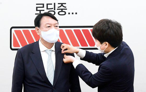 이준석 국민의힘 대표(오른쪽)가 2일 오전 서울 여의도 국회를 찾은 윤석열 국민의힘 대선 예비후보에게 입당을 축하하는 뱃지를 달아주고 있다.2021.8.2 임현동 기자