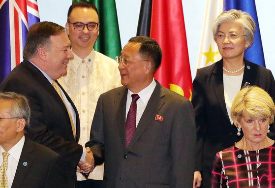 2018년 마이크 폼페이오(왼쪽) 미 국무장관과 이용호(가운데) 북한 외무상이 ARF 외교장관 회의에서 만나 악수를 나누는 모습. 북미 정상회담 2개월 후에 개최된 2018년 ARF 회의에서 이 외무상은 상호 신뢰 및 북미 관계 정상화가 이뤄져야 비핵화 조치가 시작될 수 있단 점을 강조했다. [연합뉴스]