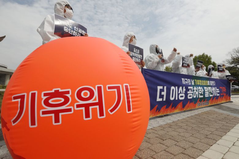 기후위기비상행동 회원들이 지구의 날인 4월 22일 청와대 분수대 앞에서 기자회견을 열고 정부에 2030년 온실가스 절반감축과 해외 석탄투자 철회, 기후정의에 입각한 정책 수립 등을 촉구하고 있다. 뉴스1