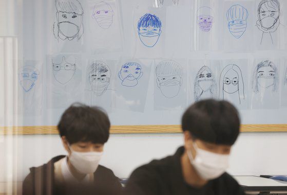 지난달 24일 오전 서울 강서구의 한 고등학교 교실 벽에 마스크를 쓴 학생들의 그림이 붙어있다.   연합뉴스