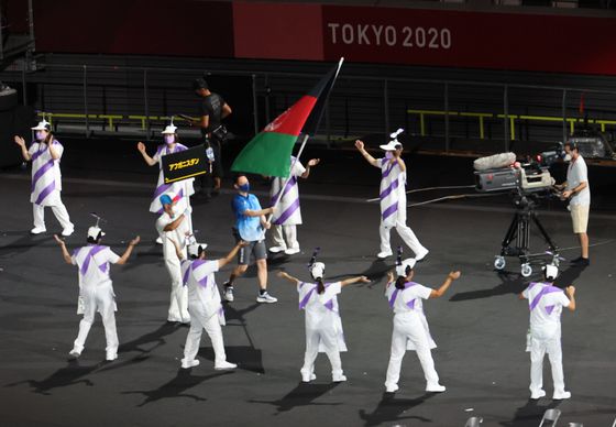 지난 24일 일본 도쿄 신주쿠의 국립경기장(올림픽 스타디움)에서 열린 2020 도쿄 패럴림픽 개회식에서 자원봉사자가 아프간 국기를 들고 입장하고 있다. [연합뉴스]