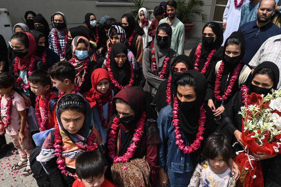아프가니스탄의 여성 청소년 축구 대표팀과 그 가족들이 15일(현지시간) 파키스탄 축구 협회에 도착한 뒤 포즈를 취하고 있다. AFP=연합뉴스