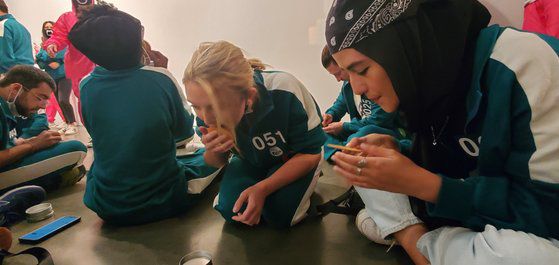 26일 미국 뉴욕에서 열린 ‘오징어 게임과 함께 하는 뉴욕 속 한국 여행’ 행사에서 참가자들이 ‘달고나 뽑기’를 하고 있다. 박현영 특파원