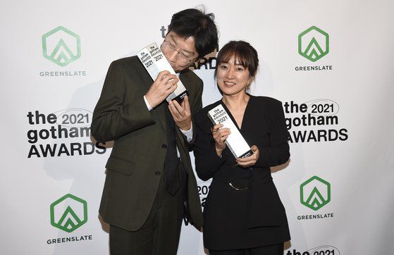 '오징어 게임' 제작자 김지연 대표(오른쪽)와 함께 고담 어워즈에서 수상한 황동혁 감독이 트로피에 입을 맞추고 있다. [AP=연합]
