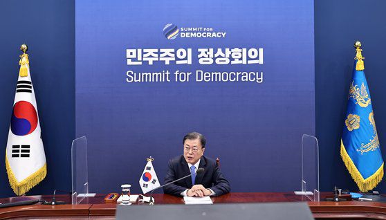 문재인 대통령이 9일 청와대 여민관에서 화상으로 진행된 민주주의 정상회의 시작에 앞서 정의용 외교부 장관으로부터 유엔평화유지군과 관련된 보고를 받은 뒤 답하고 있다. 청와대사진기자단