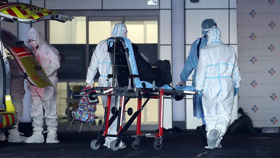 19일 서울 중랑구 서울의료원에서 의료진이 코로나19 환자를 이송하고 있다. 뉴스1