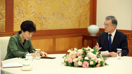 한명숙 전 총리가 대법원에서 징역형을 선고받은 뒤 국회에서 입장을 밝히고 의사당을 나서며 문재인 당시 새정치민주연합 대표와 손을 잡고 있다.