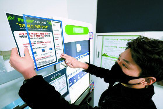 4일 서울 은평구 청구성심병원에서 한 시민이 휴대전화로 코로나19 백신 예방접종 정보를 확인하기 위해 QR 화면을 보고 있다. [뉴스1]