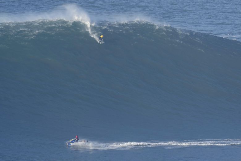 서퍼가 파도를 타고 내려오는 모습을 제트 스키어가 바라보고 있다. 서프가 위험에 처하면 즉시 구조에 착수한다. AP=연합뉴스