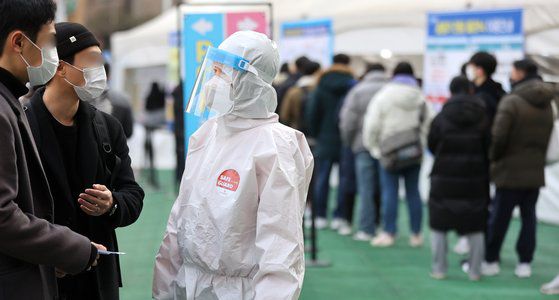 신종 코로나바이러스 감염증(코로나19) 신규 확진자 수가 5만6431명으로 나흘째 5만명대를 기록한 13일 오전 서울 송파구보건소 선별진료소에서 관계자가 검사 안내를 하고 있다. 뉴스1