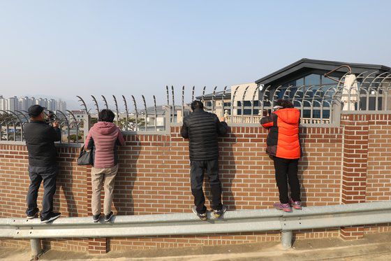 박근혜 전 대통령이 퇴원 후 정치적 고향인 대구에서 생활하기 위해 달성군 유가읍 쌍계리의 한 주택을 본인 명의로 매입한 사실이 알려진 가운데 13일 사저를 구경하려는 시민들이 건물 뒤편 가드레일 위에 올라가 담장 안을 살펴보고 있다. 뉴스1