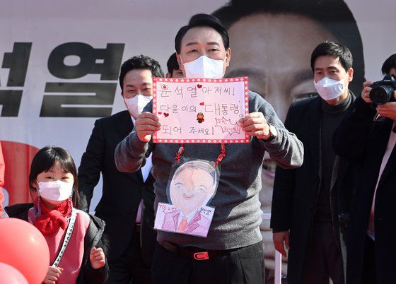 국민의힘 윤석열 당선인이 대선 후보였던 지난 8일 제주시 동문시장 일대에서 열린 ‘제주와 함께 승리합니다’ 제주도 거점유세에서 한 어린이 받은 편지를 들어보이고 있다. [공동취재, 연합뉴스]