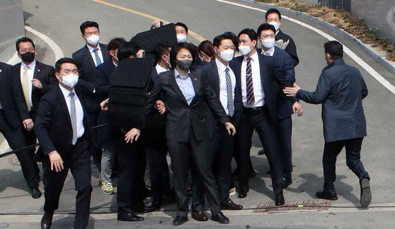 박근혜 전 대통령이 24일 낮 대구 달성군 유가읍에 마련된 사저에 도착해 시민들에게 인사말을 하던 도중 '인혁당(인민혁명당) 사건' 피해자라고 주장하는 사람이 던진 소주병이 깨지자 경호원들이 몰려들고 있다. 송봉근 기자