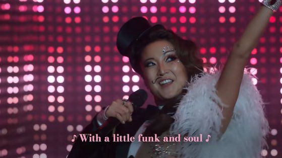 넷플릭스 오리지널 드라마 '에밀리, 파리에 가다' 시즌2에서 주인공 에밀리의 친구 민디가 BTS의 '다이너마이트'를 부르는 장면. [사진 유튜브 캡처]