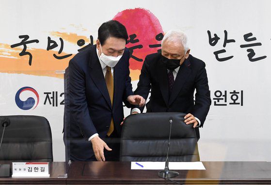 윤석열(왼쪽) 대통령 당선인이 1일 서울 삼청동 대통령직인수위원회에서 열린 국민통합위원회 1차 전체회의에 참석해 의자에 앉으려 하자 김한길 위원장이 의자를 빼주고 있다. 뉴스1