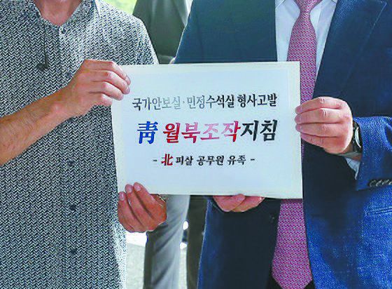 서해 해역에서 북한의 총격으로 피살된 해양수산부 공무원 이모 씨의 친형 이래진(왼쪽)씨가 22일 서울 서초구 서울중앙지방검찰청 로비에서 전 청와대 인사들에 대한 고발장을 접수하기 위해 민원실로 향하고 있다. 오른쪽은 유족 측 법률대리인을 맡고 있는 김기윤 변호사.  이 씨는 이날 서훈 전 청와대 국가안보실장, 김종호 전 민정수석비서관, 이광철 전 민정비서관을 공무집행방해죄 등 3개 혐으로 고발한다고 밝혔다. 뉴스1