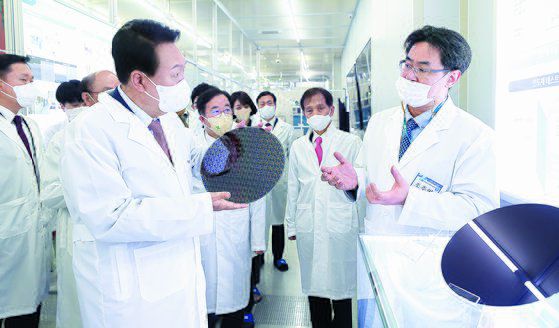 윤석열 대통령이 지난 4월 29일 오전 대전 유성구 카이스트 부설 나노종합기술원을 방문해 반도체 웨이퍼를 살펴보고 있다. [뉴스1]