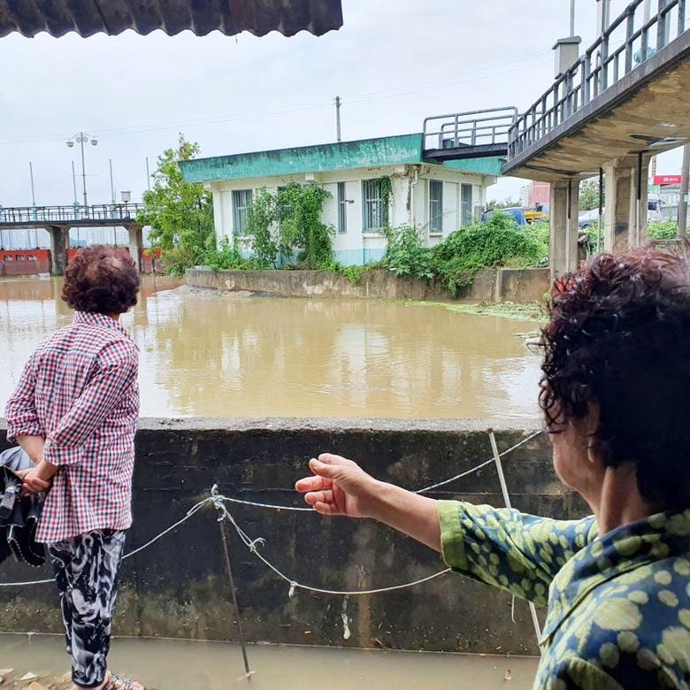 11일 호우경보가 내려진 전북 군산시 조촌동 김모(78)씨의 집 뒷마당과 맞닿은 경포천에 물이 넘실내자 주민들이 우려하고 있다. 연합뉴스