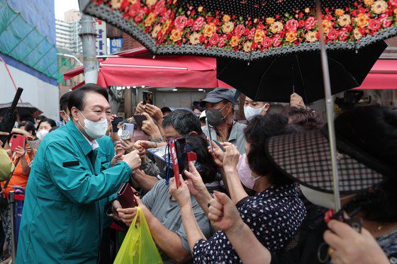 윤석열 대통령이 25일 서울 강동구 암사종합시장을 방문해 시민들과 인사를 나누고 있다. 사진 대통령실