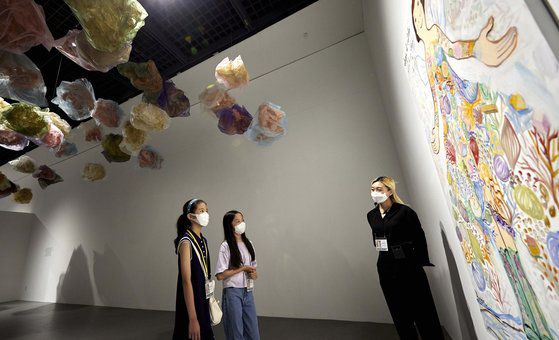 소중 학생기자단이 박유나 도슨트(맨 오른쪽)에게서 ‘영감’ 섹션의 『무슨 옷을 입을지』에 담긴 메시지를 듣고 있다.