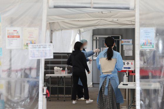 26일 오후 서울역광장에 설치된 코로나 임시선별겸사소를 찾은 시민이 검사를 받기 위해 안내를 받고 있다. 연합뉴스