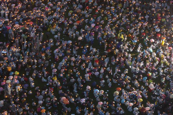 이명박 전 대통령 취임 100일을 맞은 2008년 6월 3일 미국산 쇠고기 수입 재협상을 요구하는 27번째 촛불집회가 서울시청 광장에서 열렸다. 집회에 참가한 학생과 시민들이 비를 맞으며 촛불을 밝히고 있다