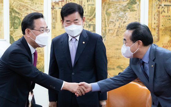 주호영 국민의힘 원내대표(왼쪽)와 박홍근 더불어민주당 원내대표가 지난 21일 오후 서울 여의도 국회에서 열린 국회의장 주재 교섭단체 원내대표 주례회동에서 악수를 하고 있다. 뉴스1