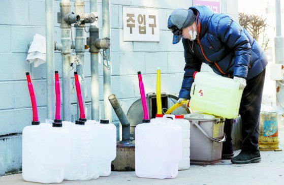 화물연대의 집단운송거부가 12일째 이어진 5일 서울 한 주유소에서 경유가 바닥나자 관계자가 승용차로 인근 주유소에서 경유를 구입, 저장고에 넣고 있다. 연합뉴스