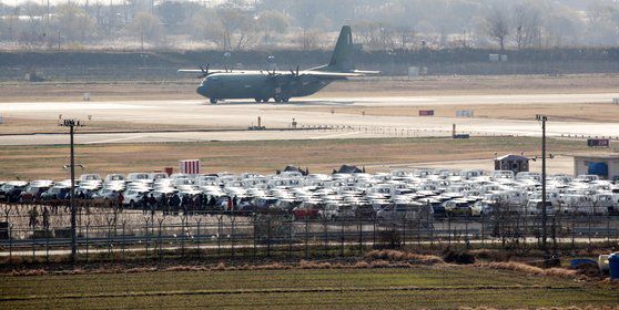 화물연대의 잡단운송거부 13일째인 6일 광주공항 활주로 옆 공간에 '로드탁송'으로 옮겨진 기아 신차들이 적치돼 있다. 기아는 화물연대 파업에 따른 카캐리어 운송이 중단되며 대체 인력을 고용해 공장에 쌓여가는 완성차를 임시 적치장으로 옮기고 있다. 연합뉴스